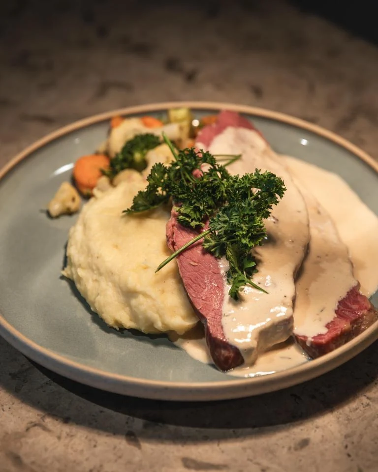 Skivat kött med gräddsås, potatismos och örter